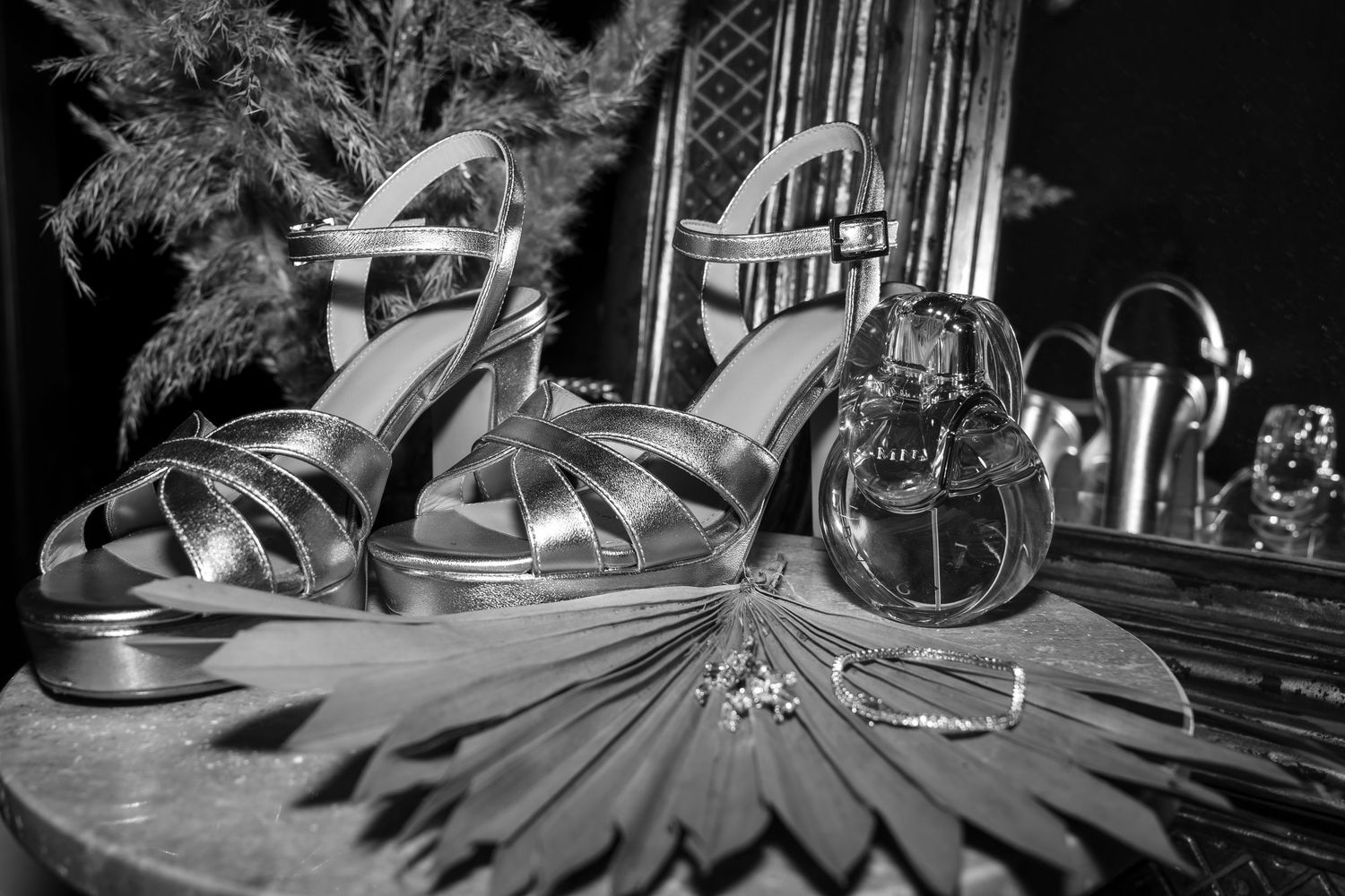 Silver wedding shoes and accessories arranged in elegant black and white still life.