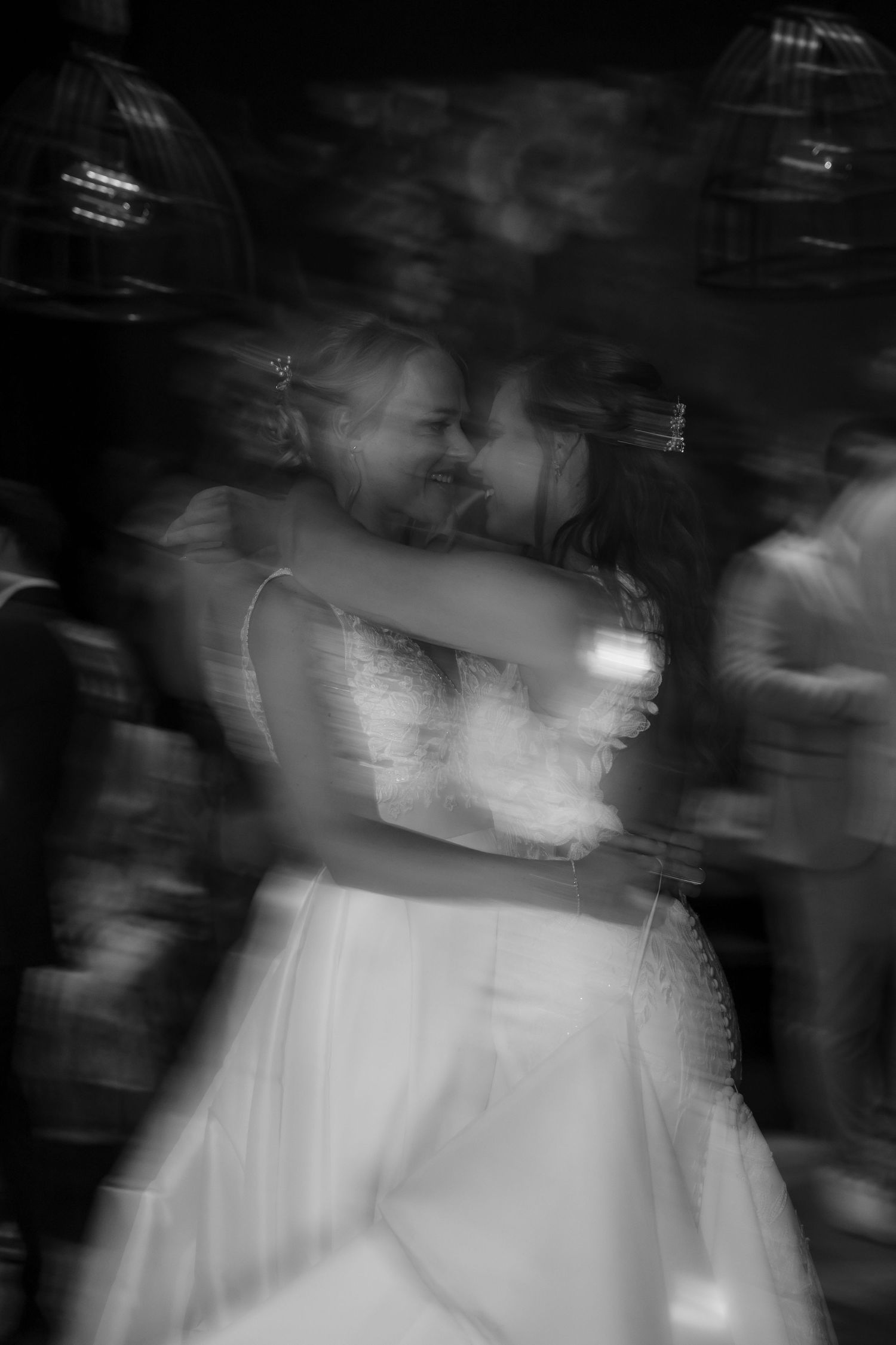 Artistic black and white motion blur capture of wedding couple dancing.