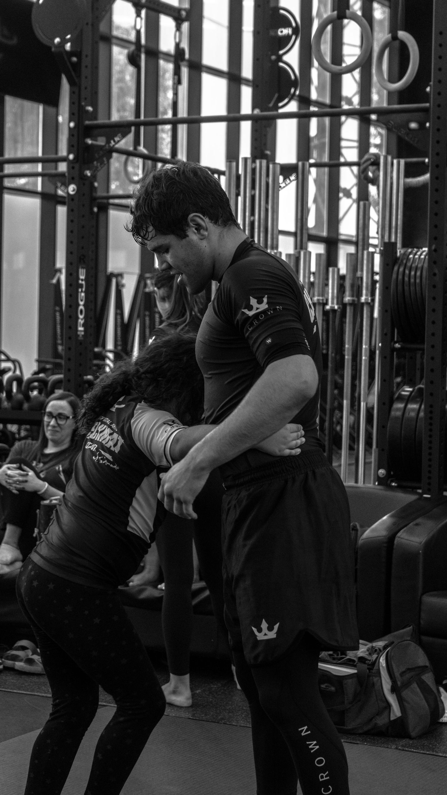 Black and white photo of two martial artists in a standing clinch and wrestling exchange during training