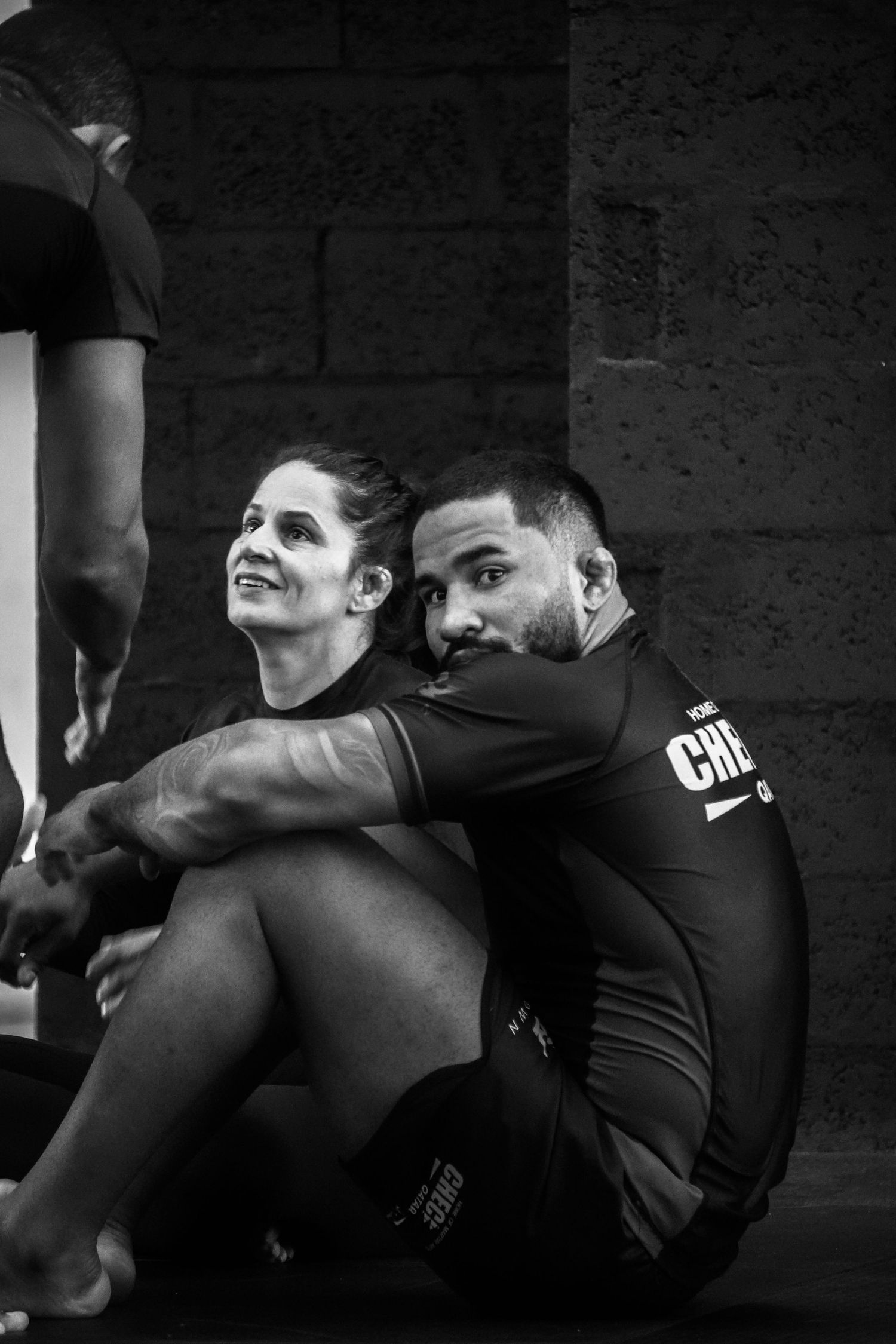 Two BJJ practitioners grappling in a black and white action photo during a rolling session