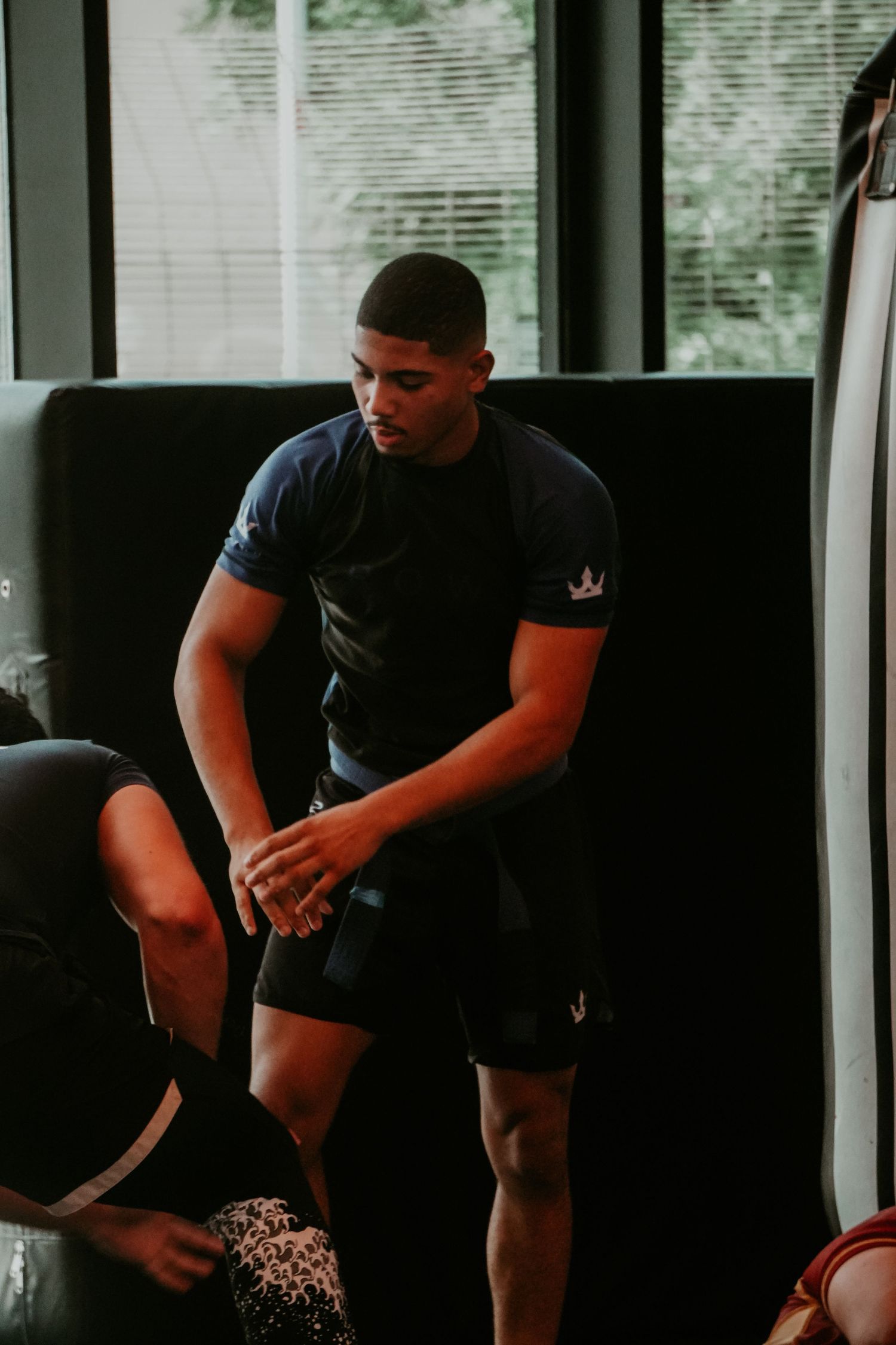 Male martial artist resting between training rounds in a gym setting