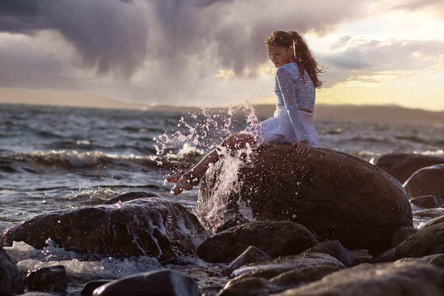 Sagolik fotografering av flicka på stenarna vid stranden i Lysekil utanför Göteborg, fotograferat av Cecilia Elgham.