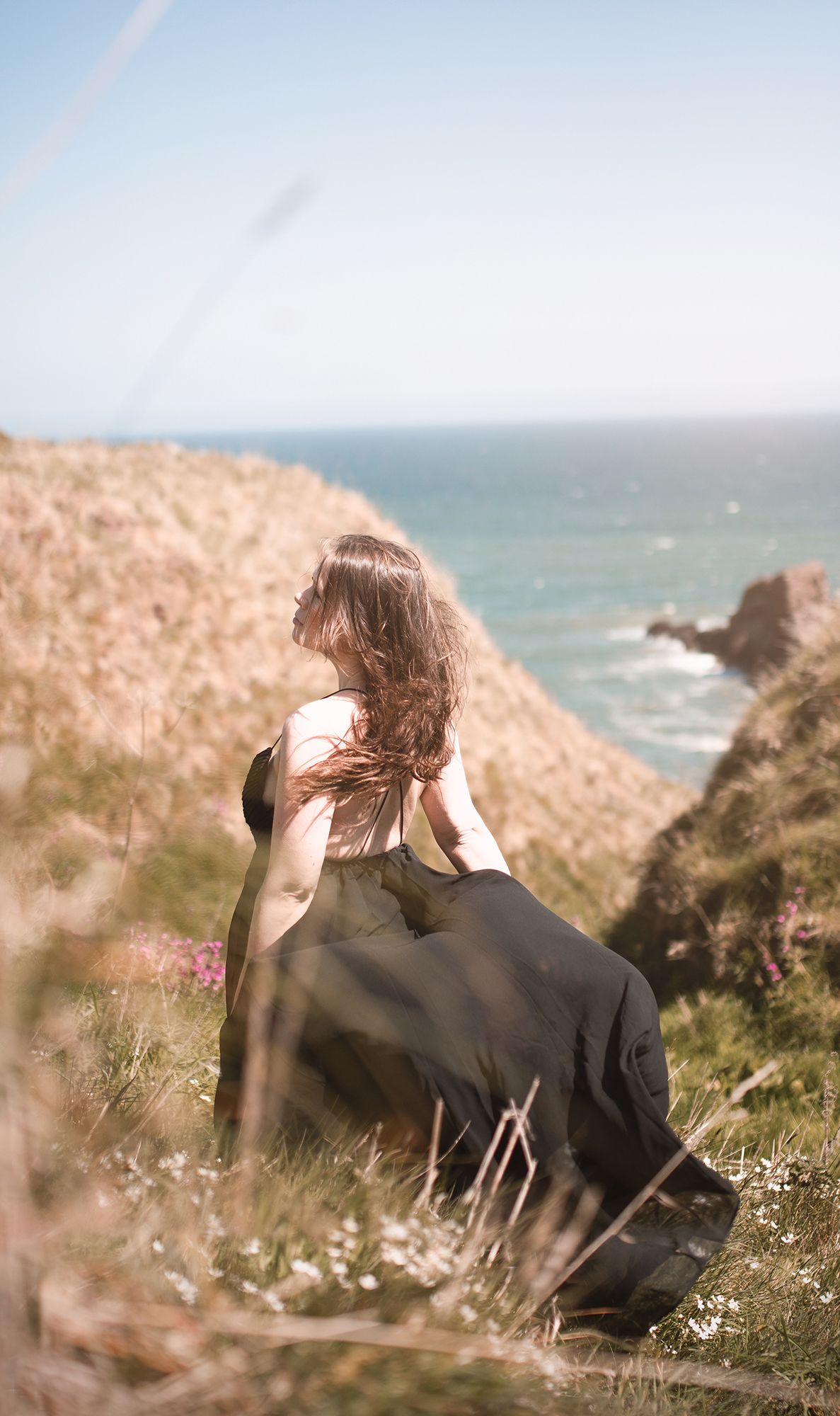 Vacker kvinna fotograferad vid sagolika Dunnottar Castle, Scotland i mjukt naturligt ljus av fotograf Cecilia Elgham
