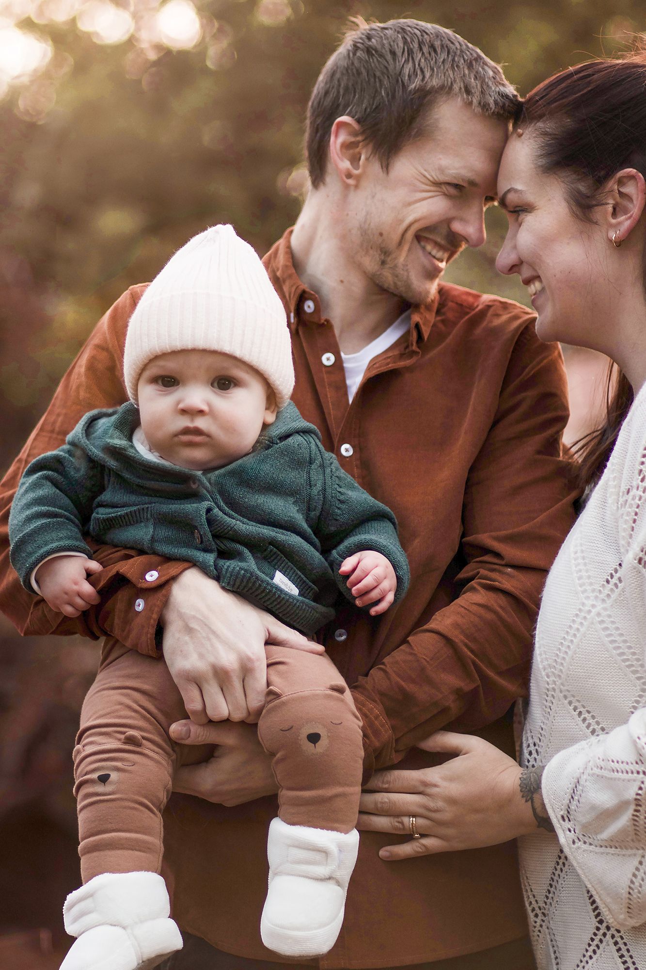 Familjefotografering av fotograf i Lysekil och Göteborg, föräldrar med bebis i famnen, varm och naturlig utomhusmiljö.