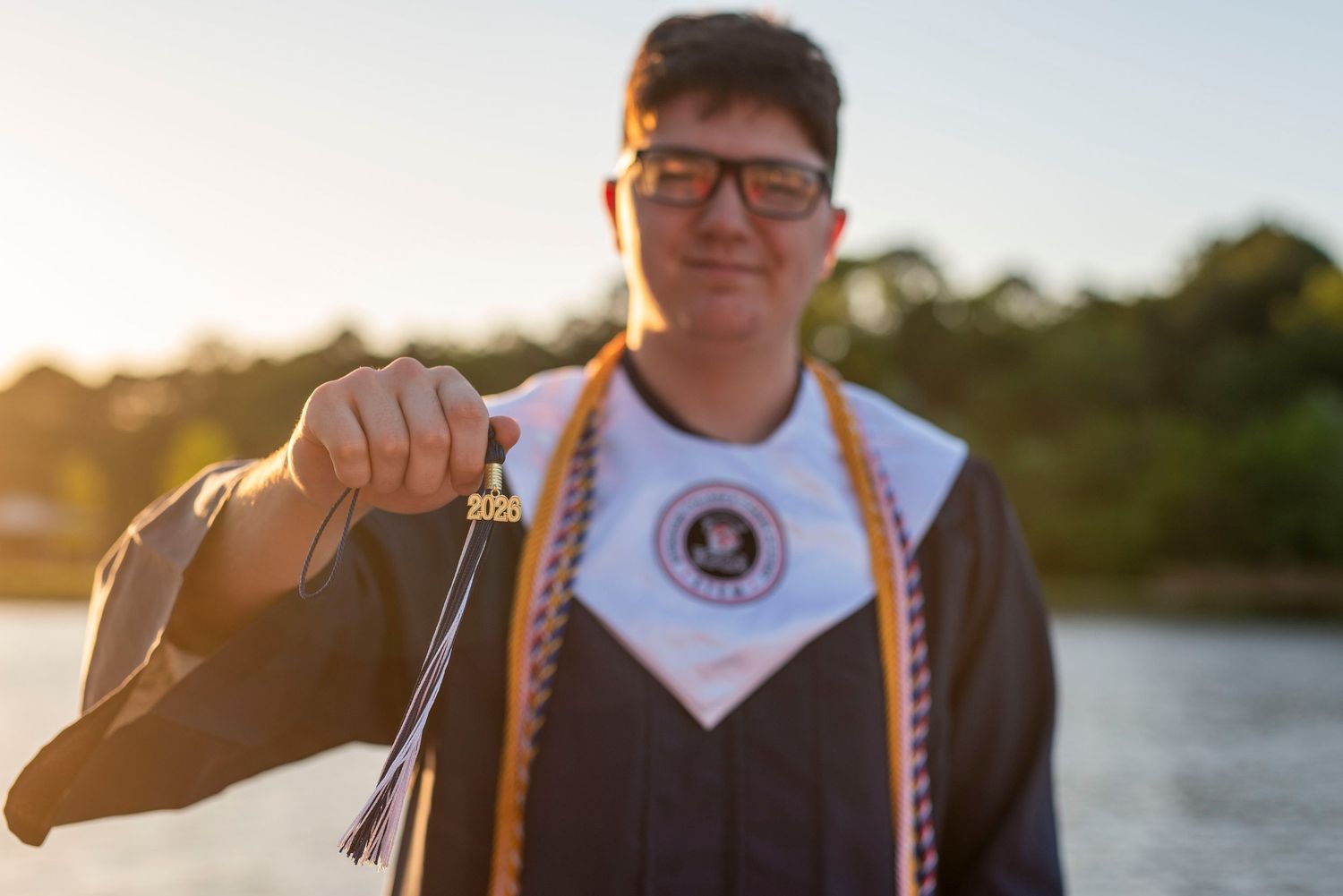 Graduating senior holding his graduation cap tassel during an outdoor senior portrait session in Springfield, Georgia.