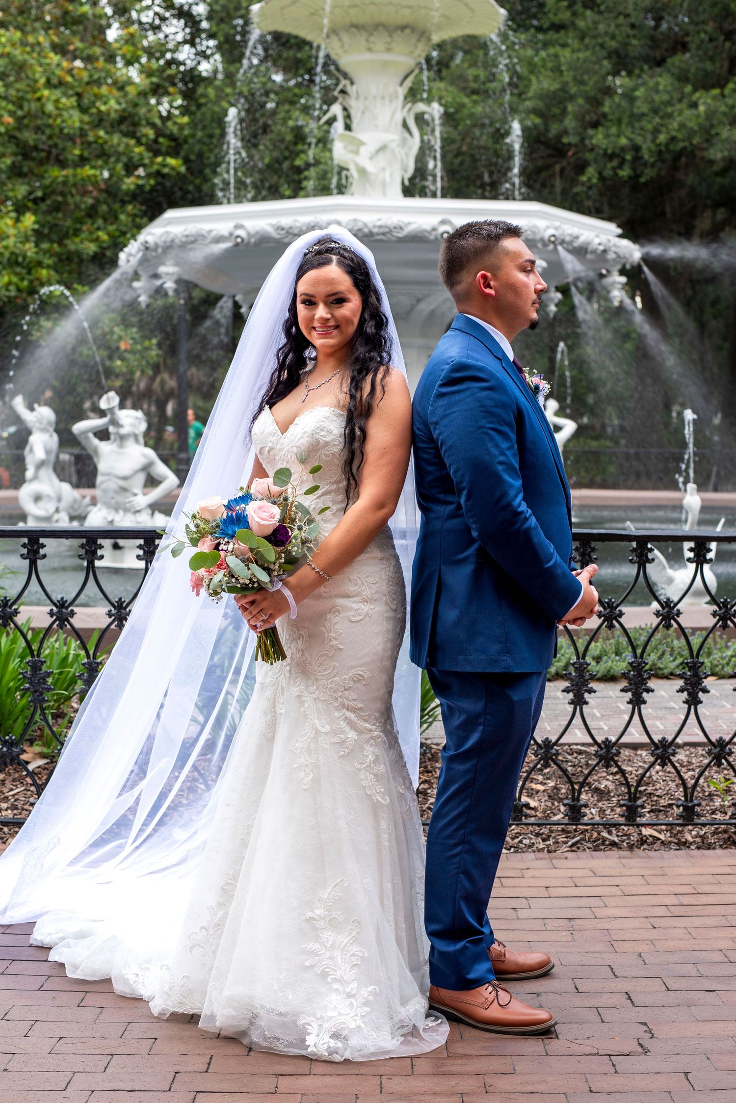 Wedding couple posing in front of the Forsyth Park fountain in Savannah, Georgia, before their wedding ceremony.