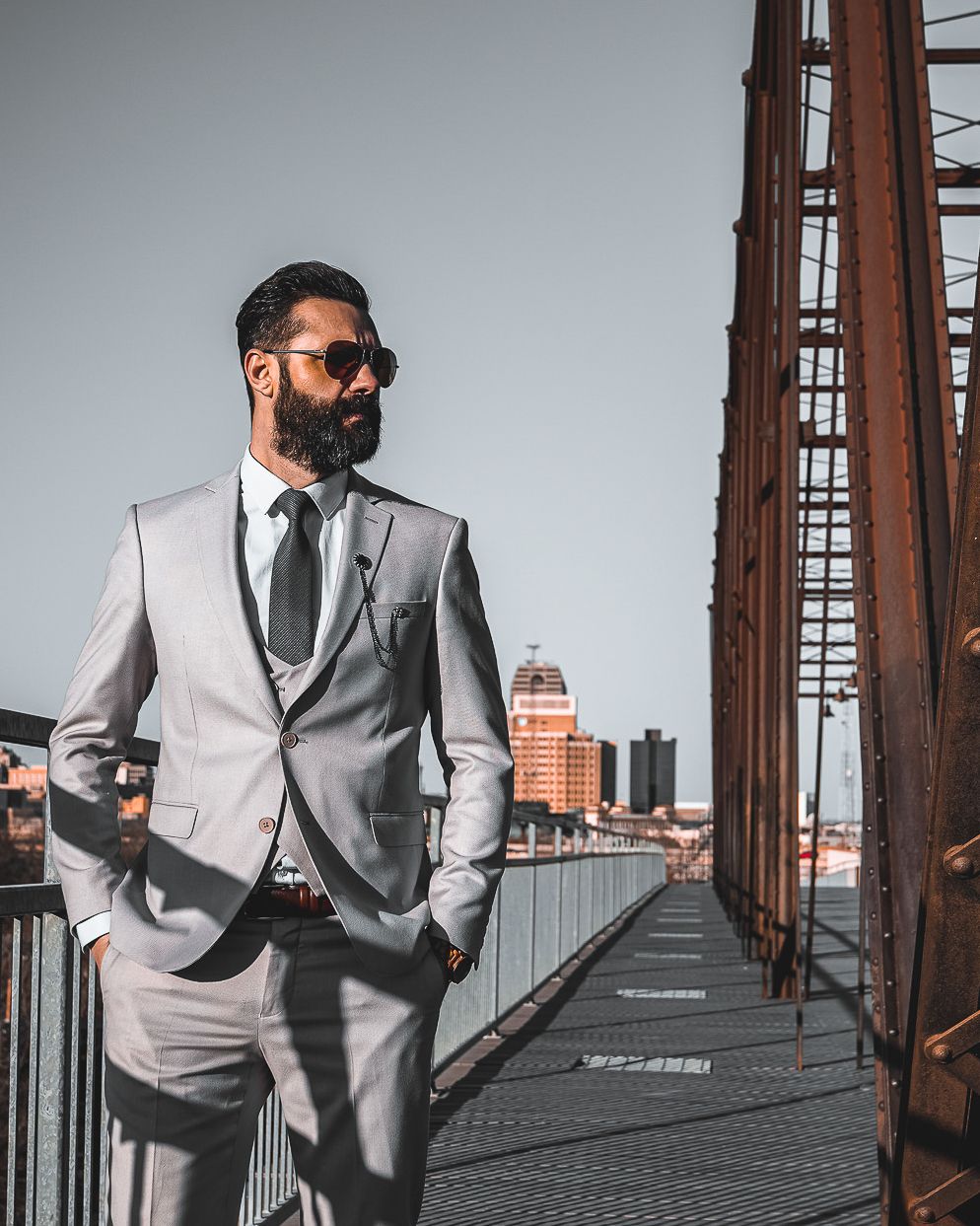 Male model in three-piece suit posing on Dolton San Antonio bridge, GQ-style commercial brand photo by Ten X Captures.