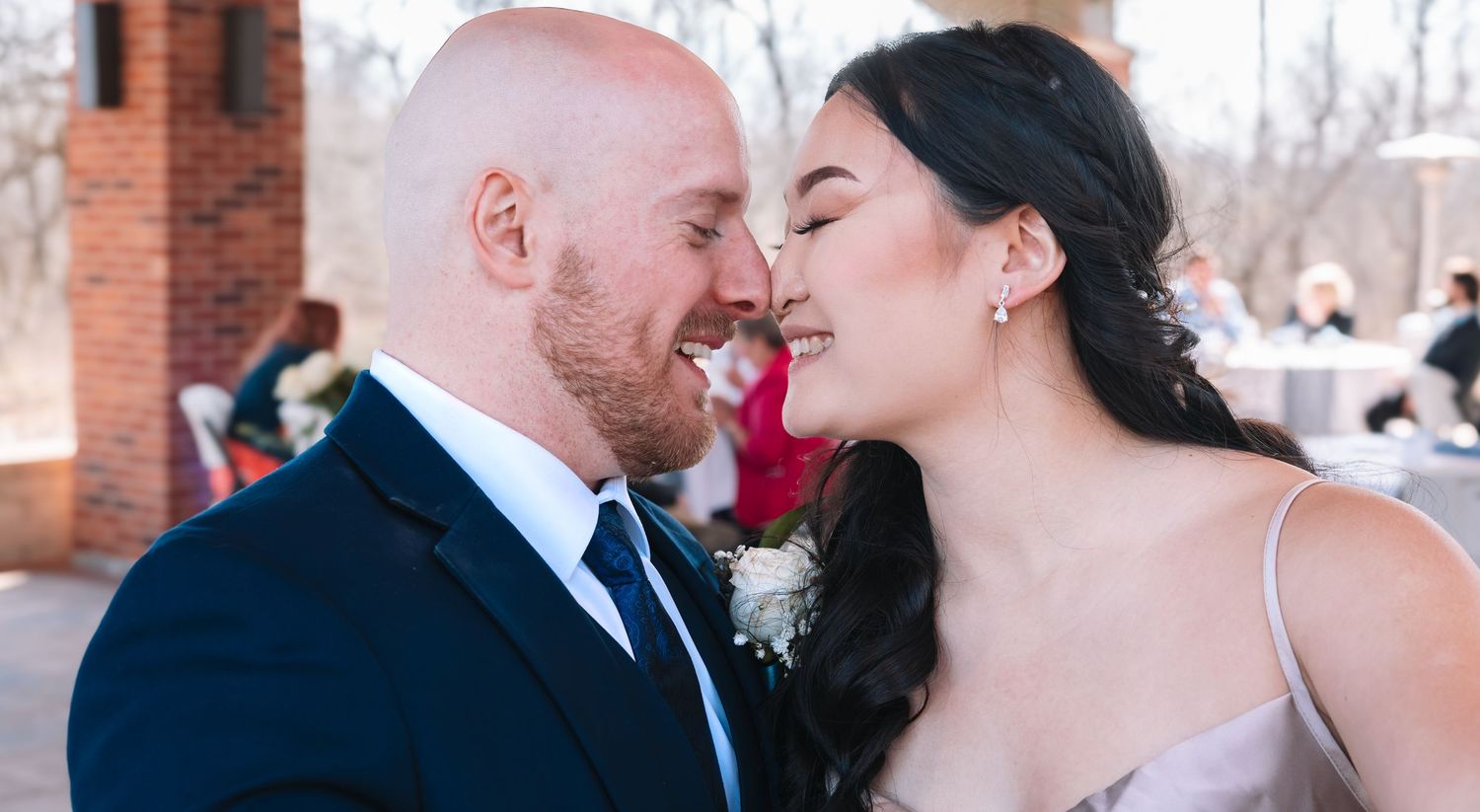 A bride and groom share a tender nose-to-nose moment at their outdoor winter wedding.