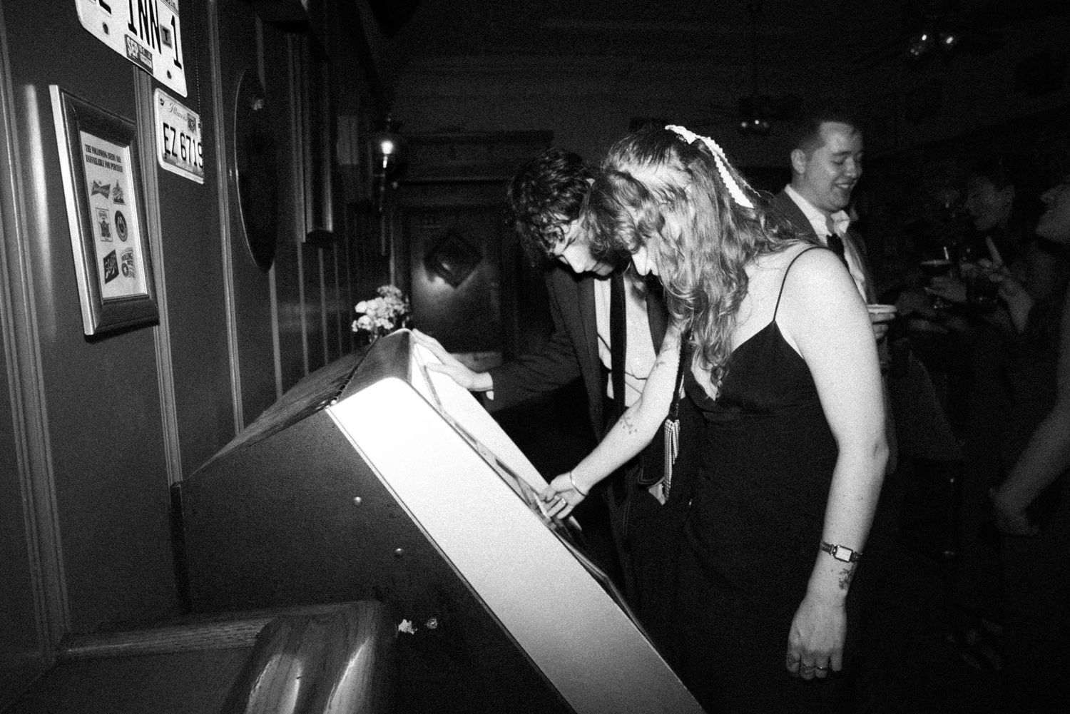 Black and white photo of elegantly dressed guests at a formal evening event.