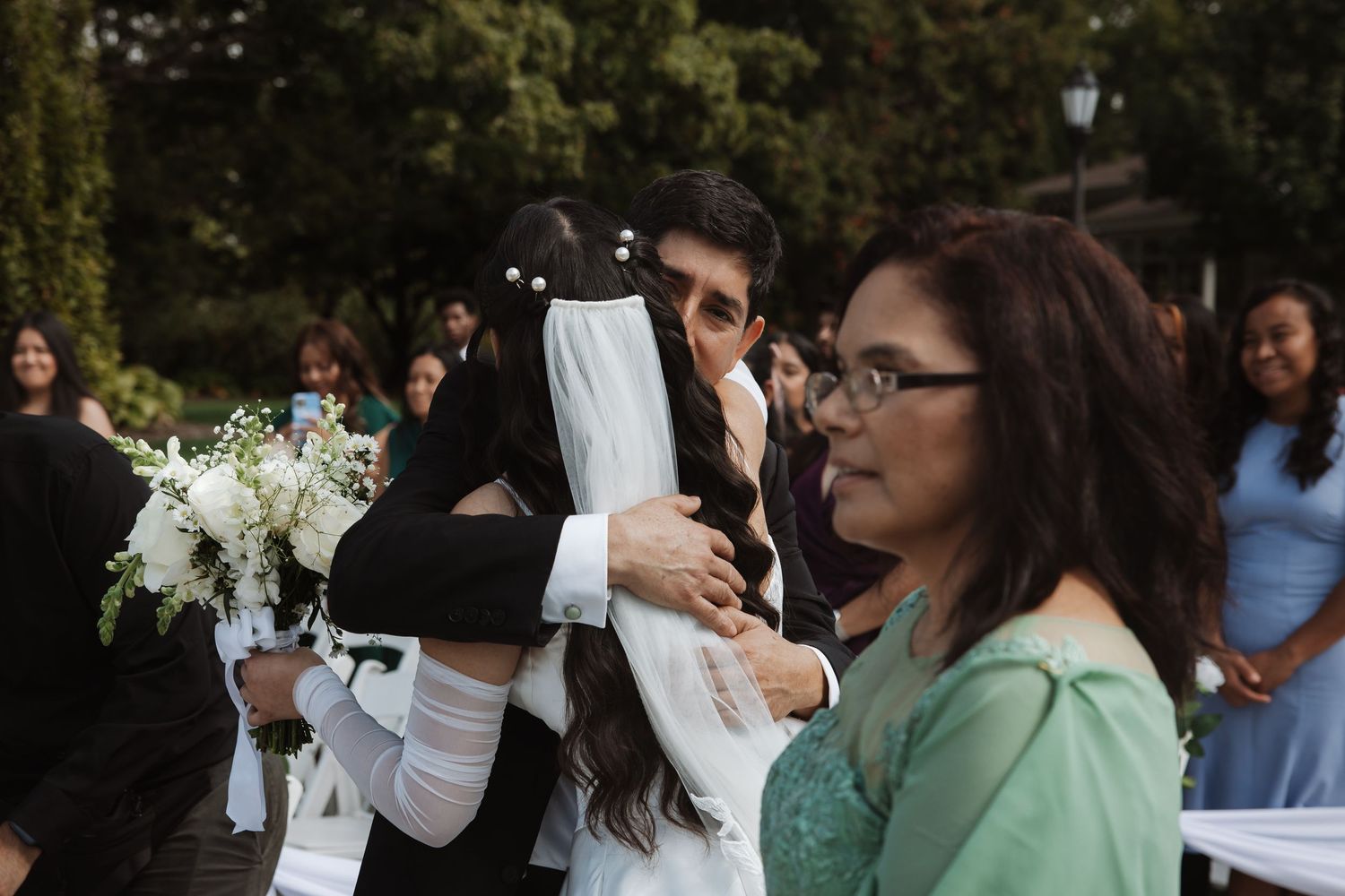 Bride and groom share an emotional hug at the altar during their outdoor wedding ceremony.