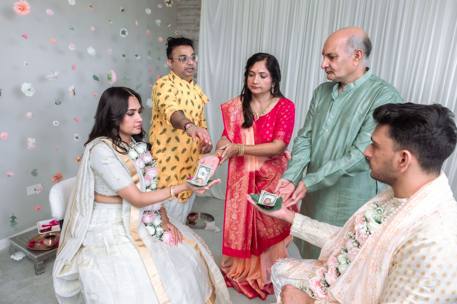Family members gather around the bride and groom during a traditional Indian wedding ritual ceremony.