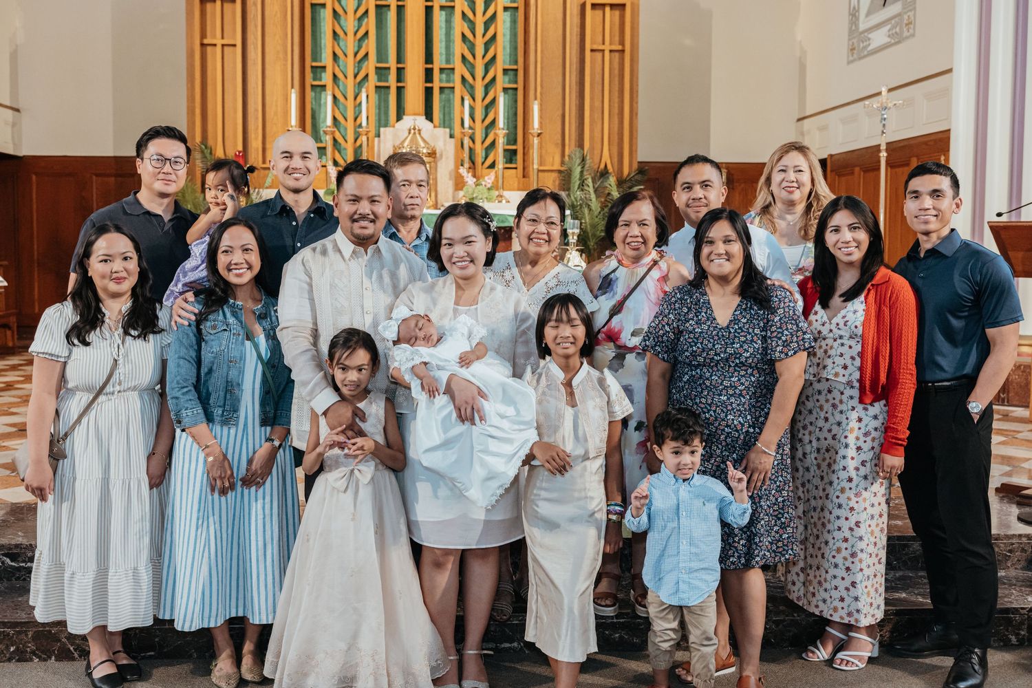 Large Filipino family group photo inside church following a baptism ceremony.