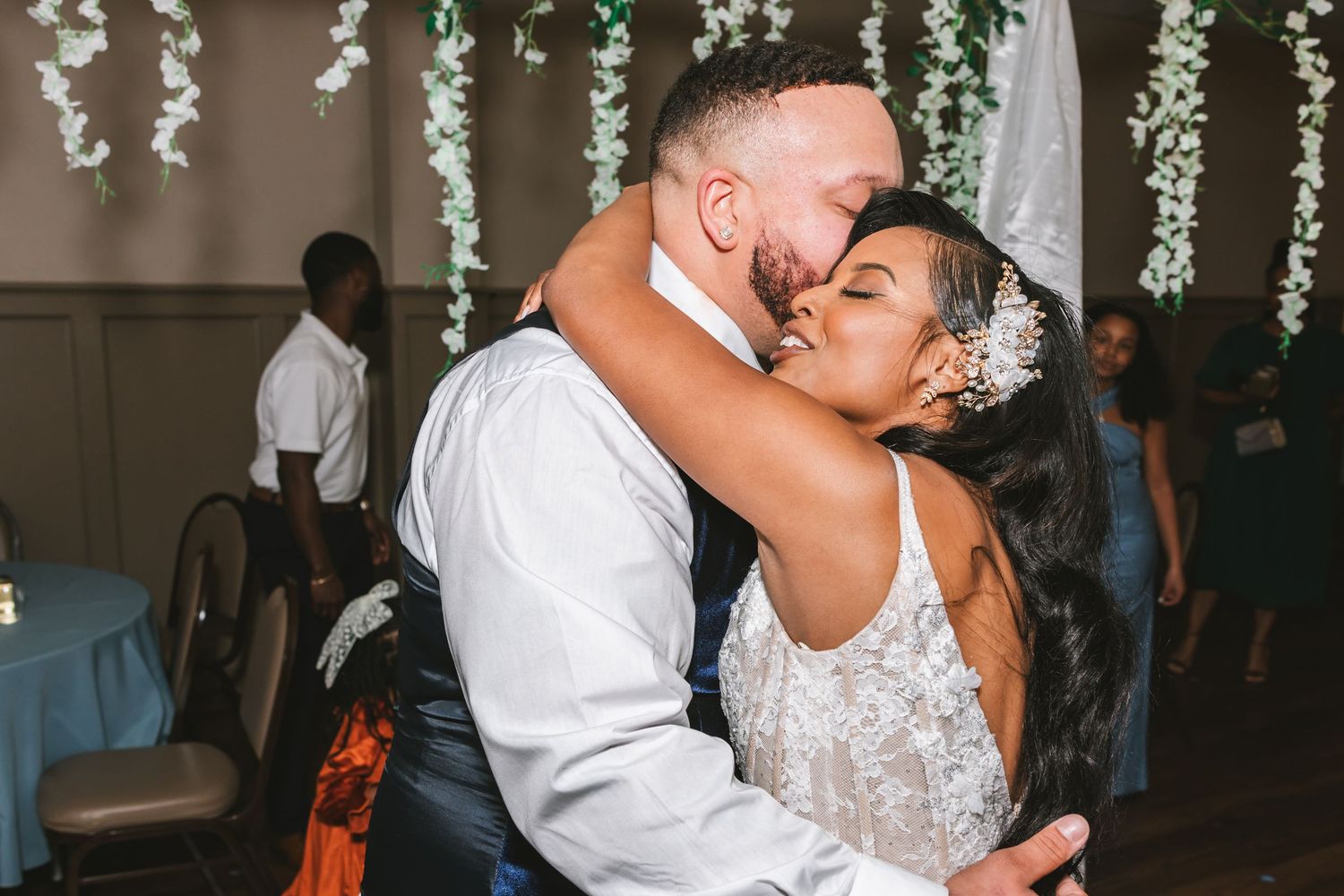 Bride and groom sharing a romantic embrace during their first dance at wedding reception.