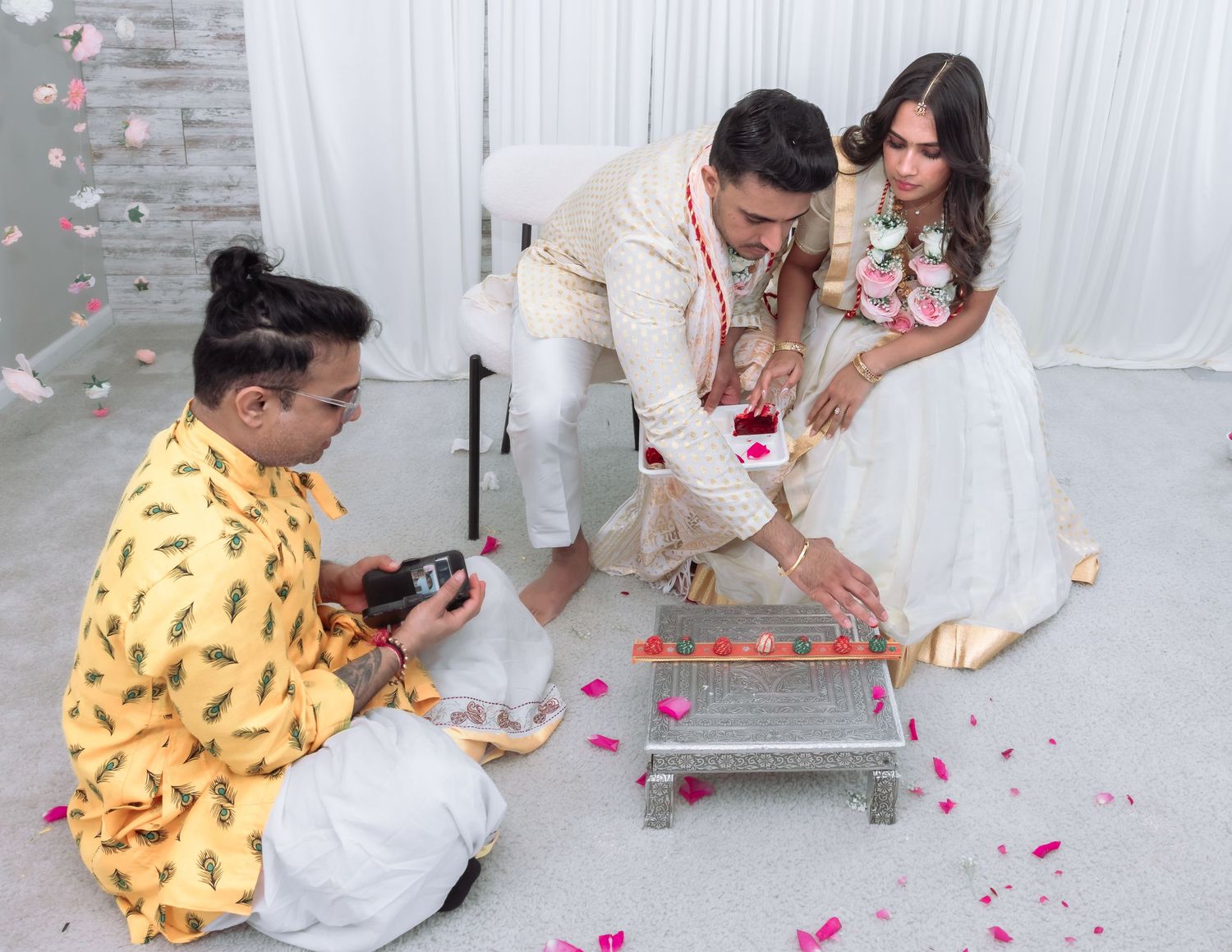 Overhead view of Hindu wedding ritual with priest, groom, and bride performing traditional ceremony.