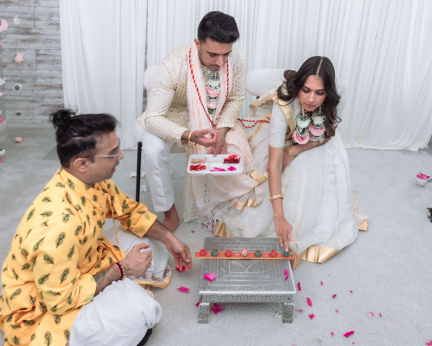Indian bride and groom participating in traditional Hindu wedding ritual with decorated ceremonial tray.
