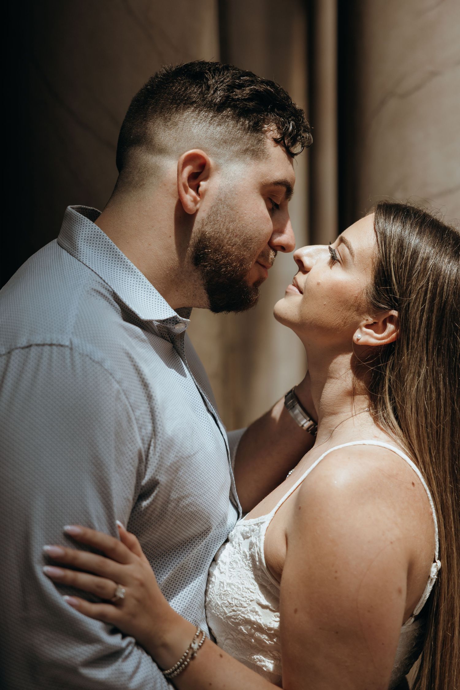 Couple nearly kissing in an intimate close-up portrait during their museum engagement session.