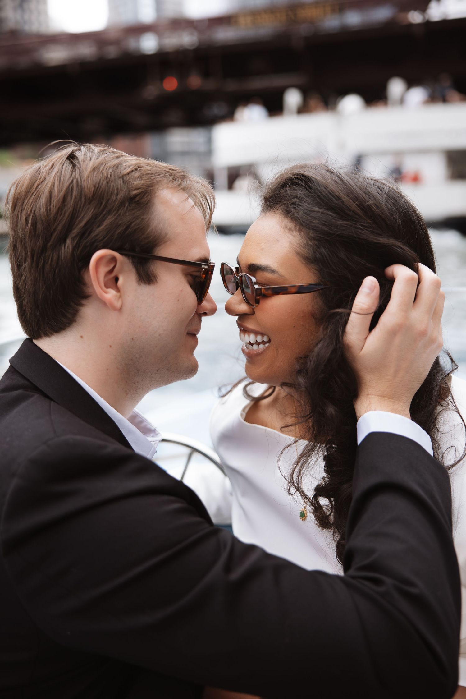 Close-up of a smiling couple in sunglasses sharing a tender moment on a boat in Chicago.