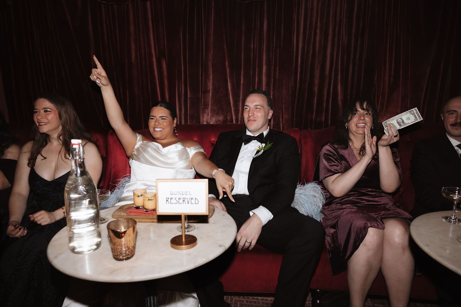 Bride and groom celebrate at their wedding reception at an elegant venue with guests.