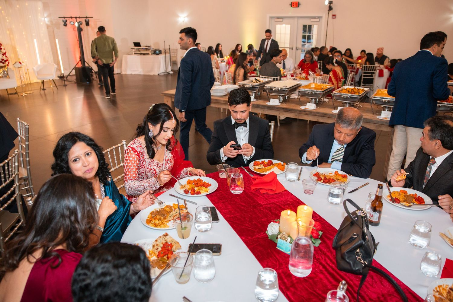 Guests dining at round tables during elegant wedding reception banquet.