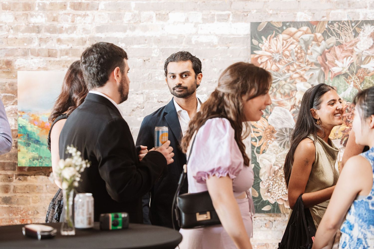 Guests mingling with drinks at an upscale art gallery social event.