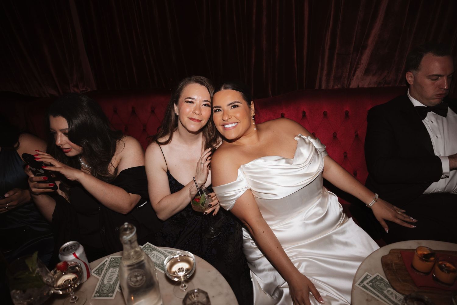 Two women smiling and posing together at an elegant evening event in formal attire.