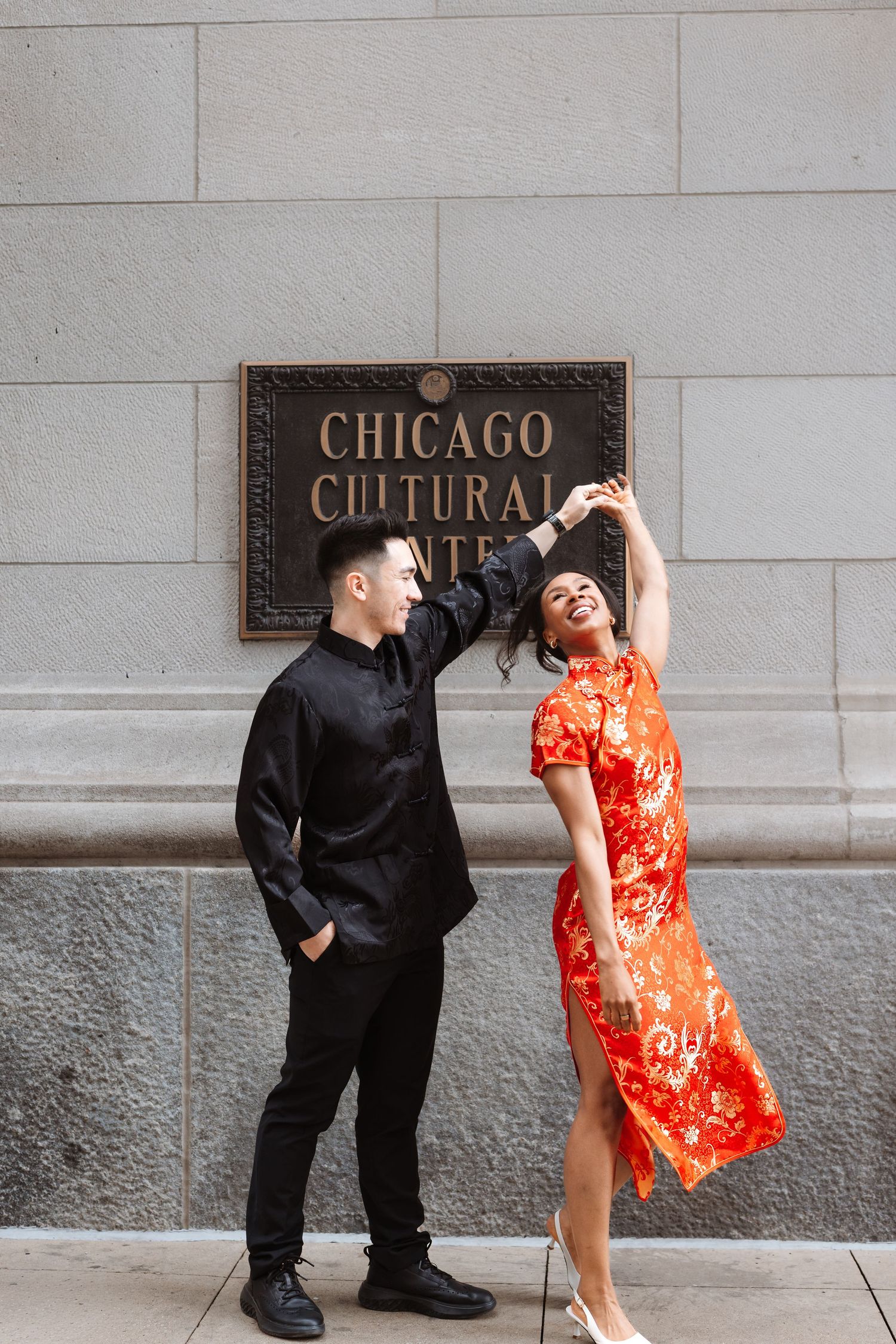 Couple dancing near Chicago Cultural Center sign, woman in red qipao being twirled by man in black.

Chicago Wedding Photographer