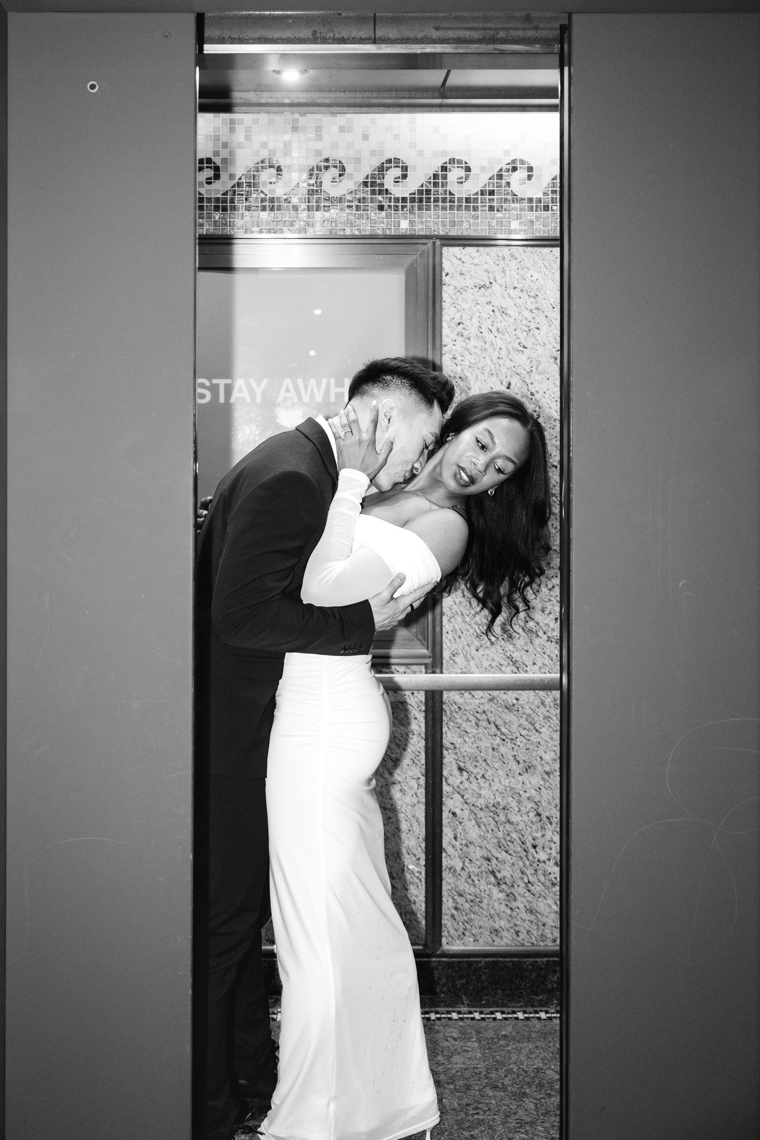 Black and white photo of bride and groom sharing an intimate moment in an elevator.Chicago Wedding Photographer