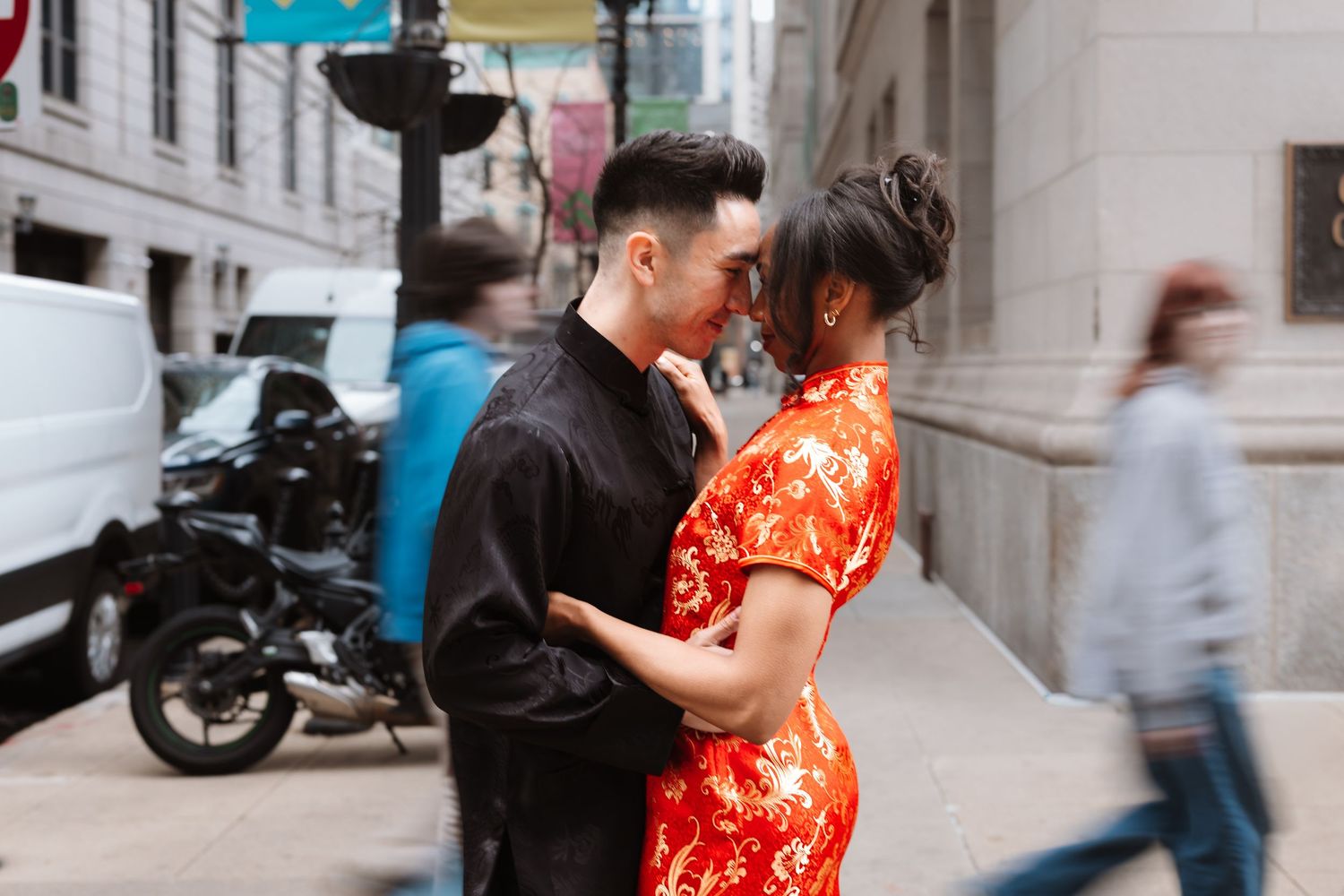 Couple in traditional Chinese attire sharing an intimate moment amid blurred pedestrians on city street.

Chicago Wedding Photographer