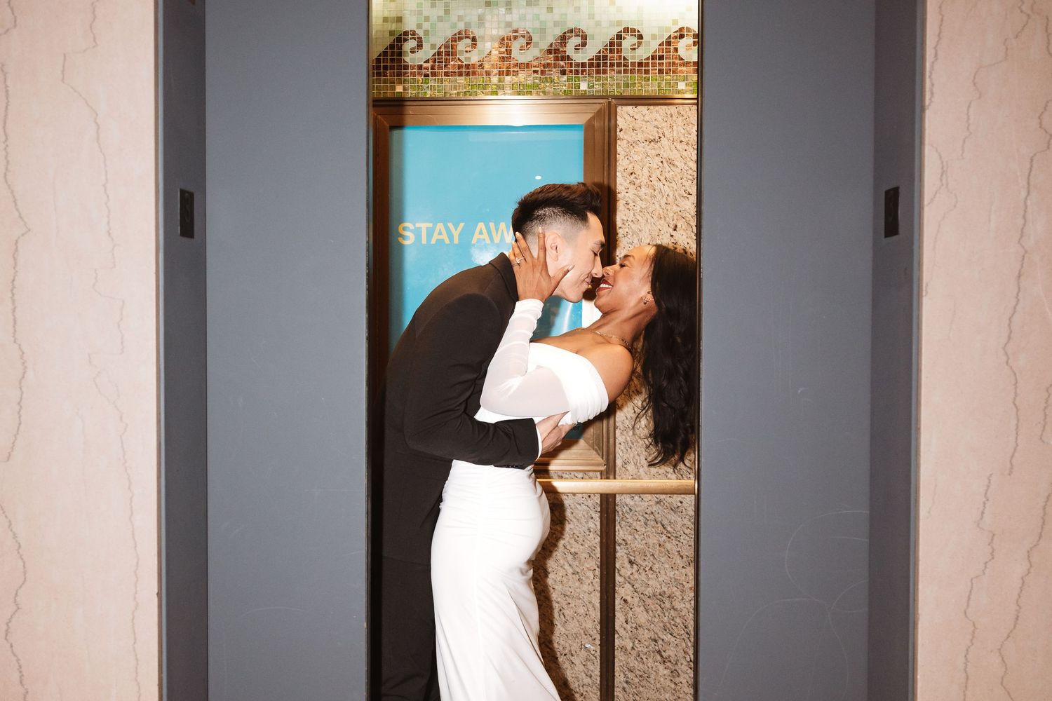 Bride and groom sharing a romantic kiss inside an elevator on their wedding day.Chicago Wedding Photographer