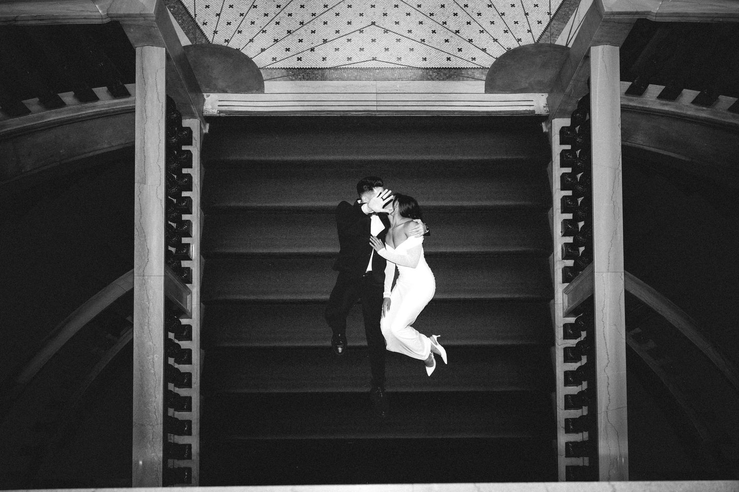 Elegant black and white overhead wedding photo of couple embracing on ornate staircase.Chicago Wedding Photographer
