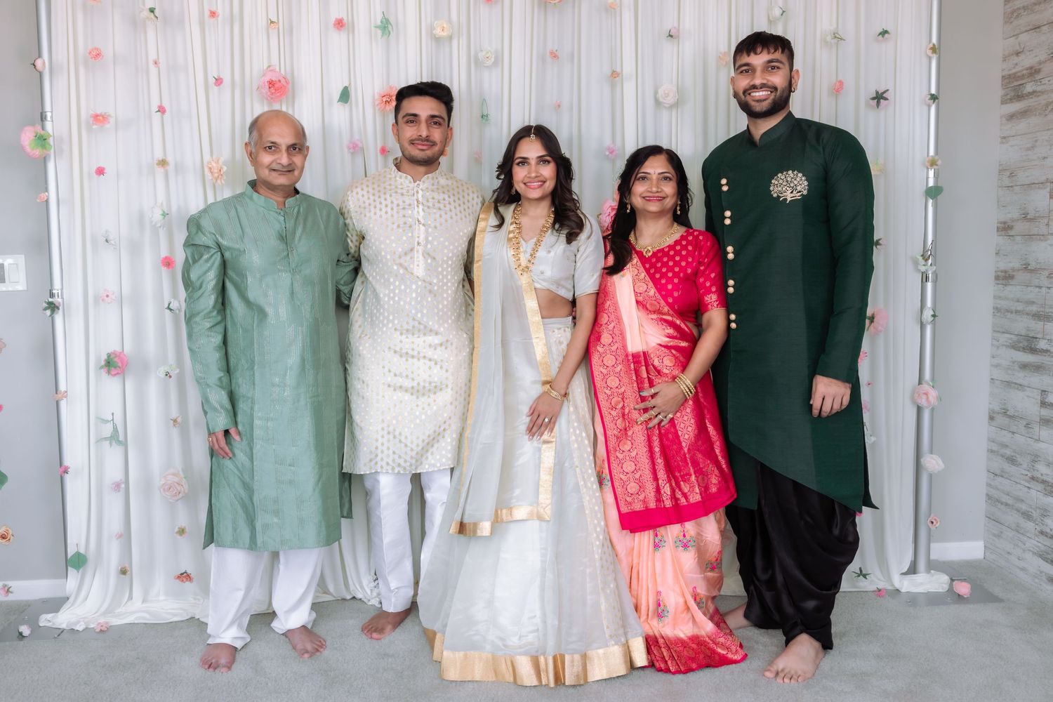 Indian family posing together in traditional attire including sarees and sherwanis at a wedding celebration.