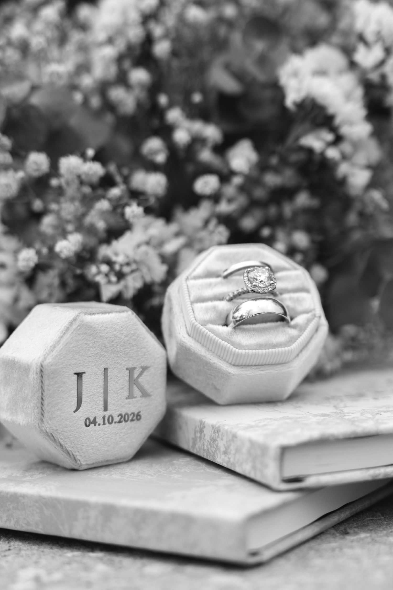 Black and white photo of wedding rings in monogrammed velvet box with initials J and K dated 04.10.2026.