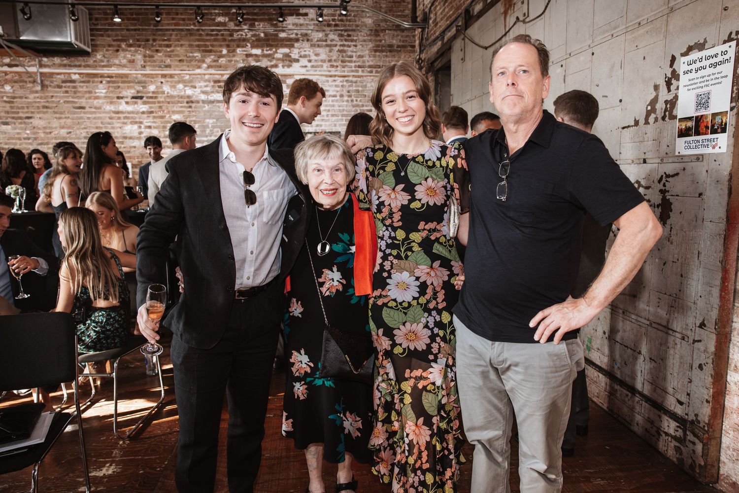 Family of four poses together smiling at an elegant social event in industrial venue.