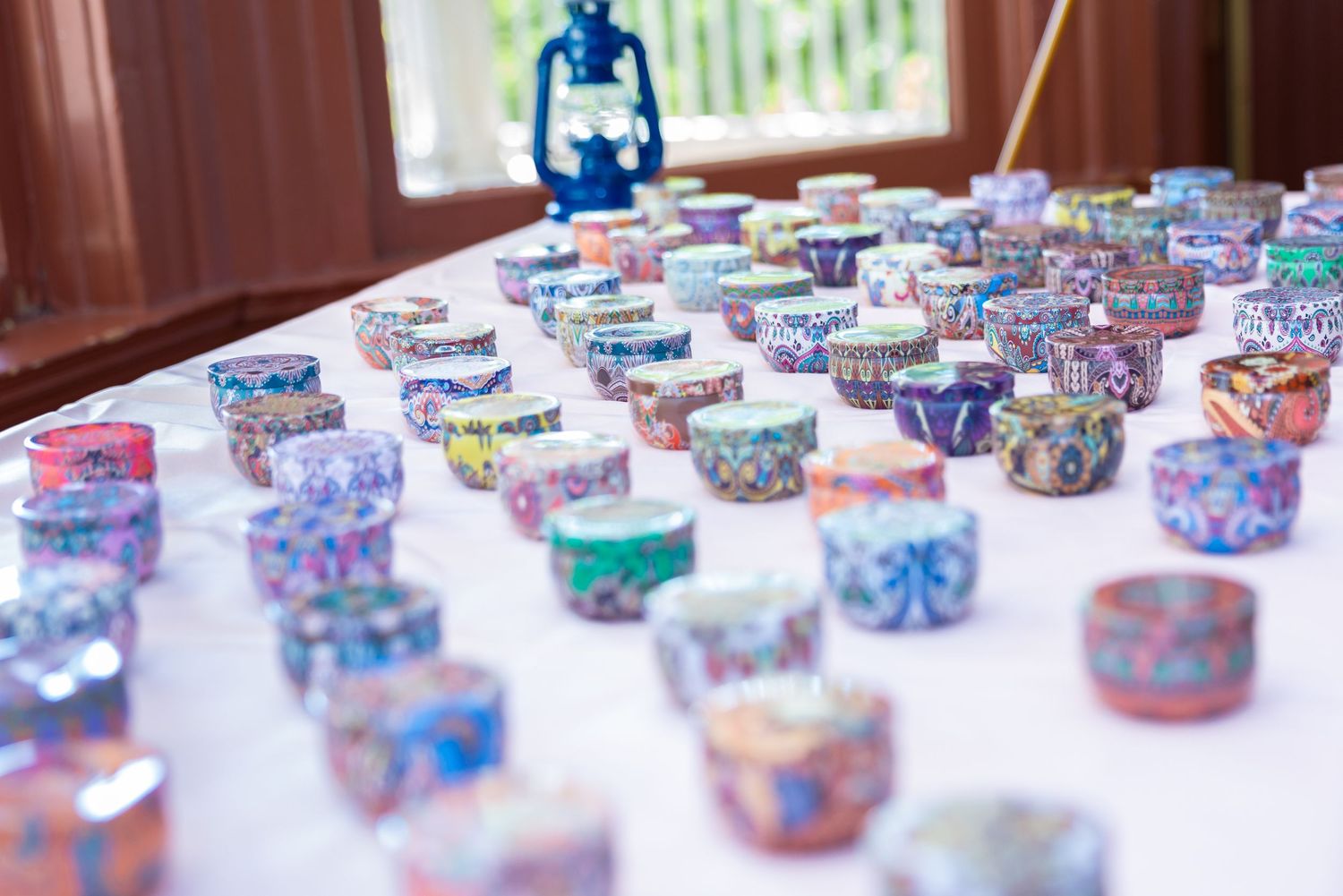 Colorful decorative bangles and bracelets displayed in rows on a white table at an Indian wedding celebration.