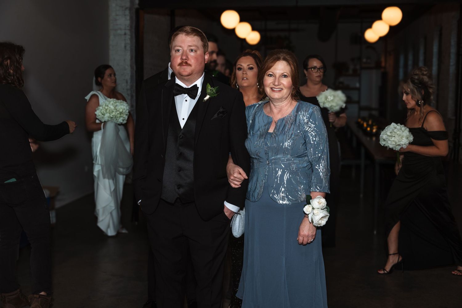 Couple in formal wedding attire walking arm in arm during wedding processional.