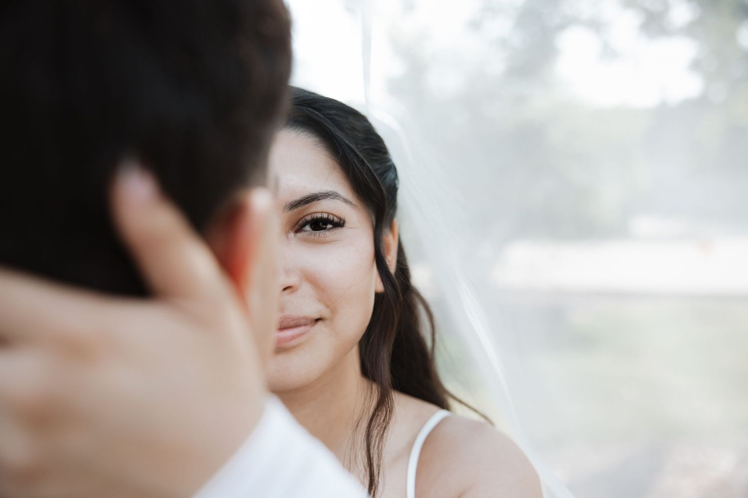 Beautiful bride gazing at groom with soft romantic expression on her wedding day.