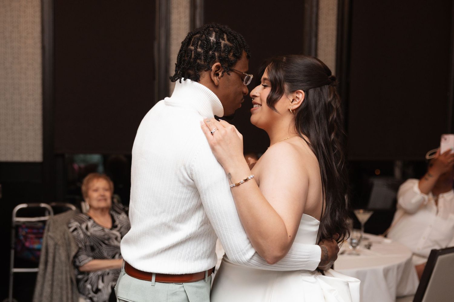Bride and groom share intimate first dance moment at wedding reception.