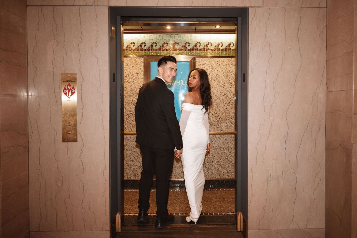 Bride and groom sharing an intimate glance inside a gold-trimmed elevator on their wedding day.Chicago Wedding Photographer