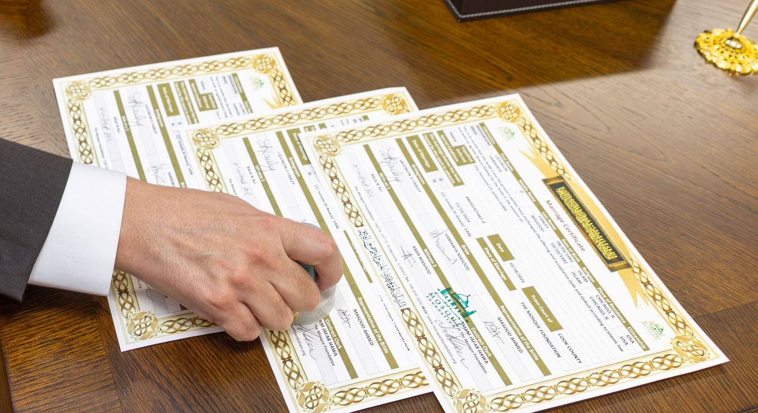 Close-up of official Islamic marriage certificate documents on a wooden desk during a Nikkah ceremony.
