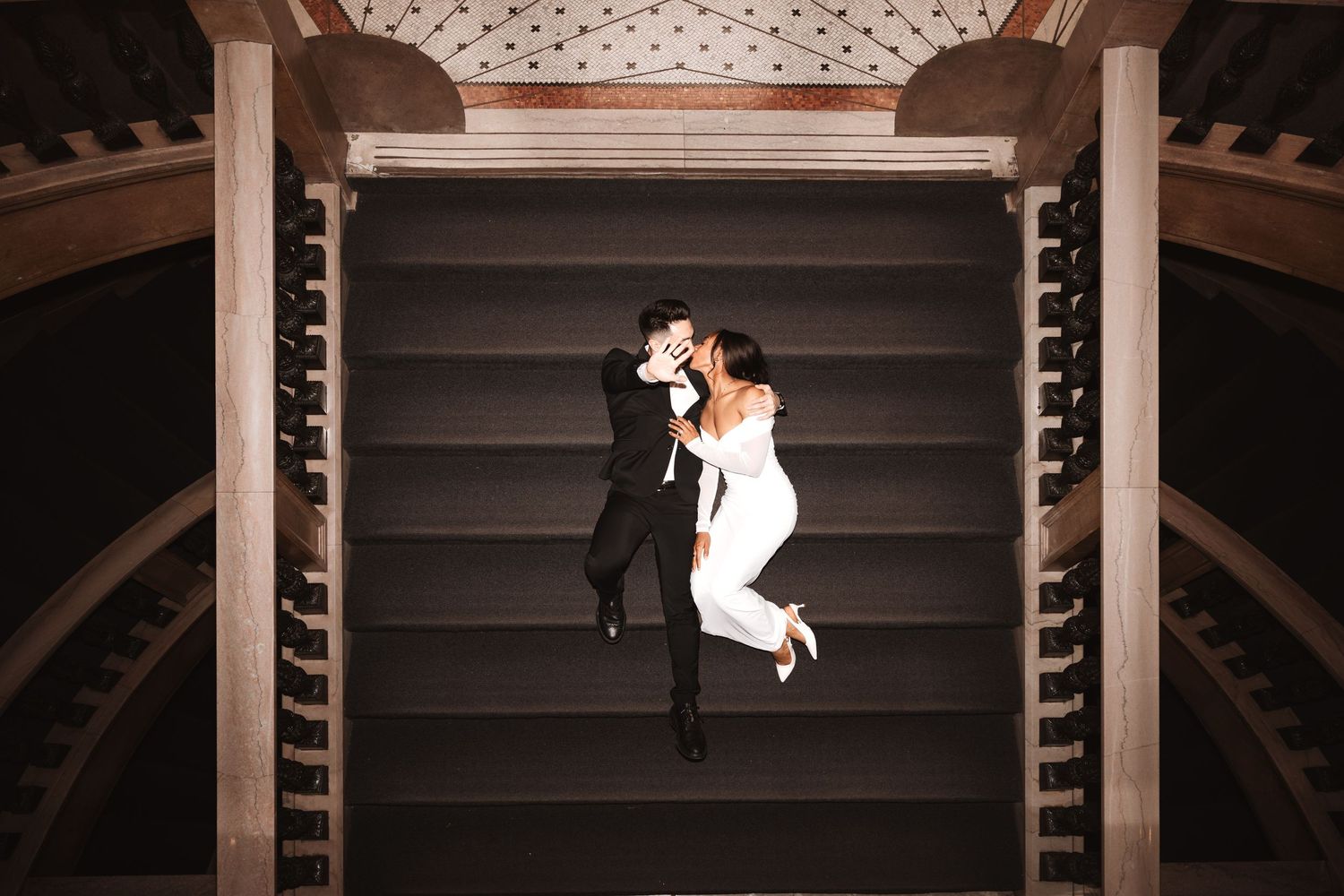 Aerial shot of couple sharing a kiss on elegant staircase during wedding photo session.Chicago Wedding Photographer