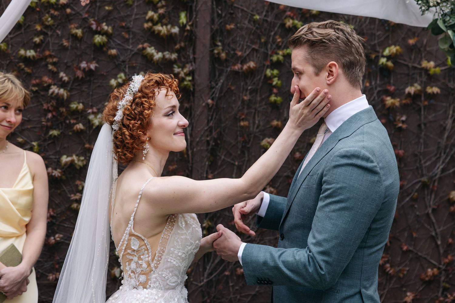 Bride tenderly touches grooms face during emotional outdoor wedding ceremony exchange.