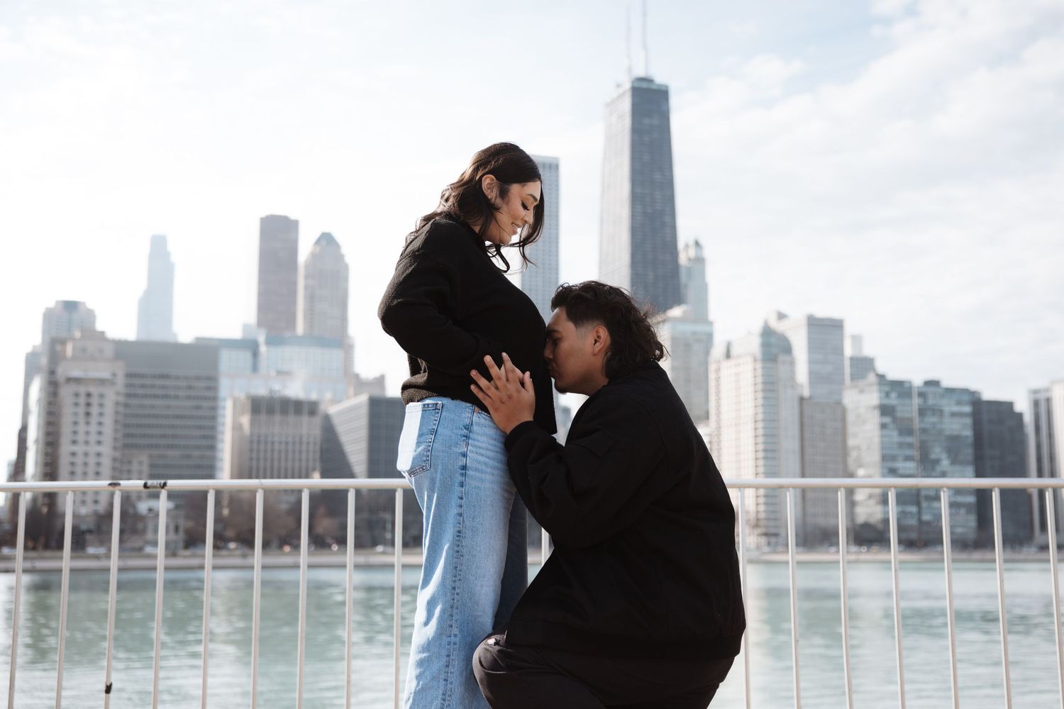 Couple shares romantic moment by Chicago fountain with iconic city skyline behind them.