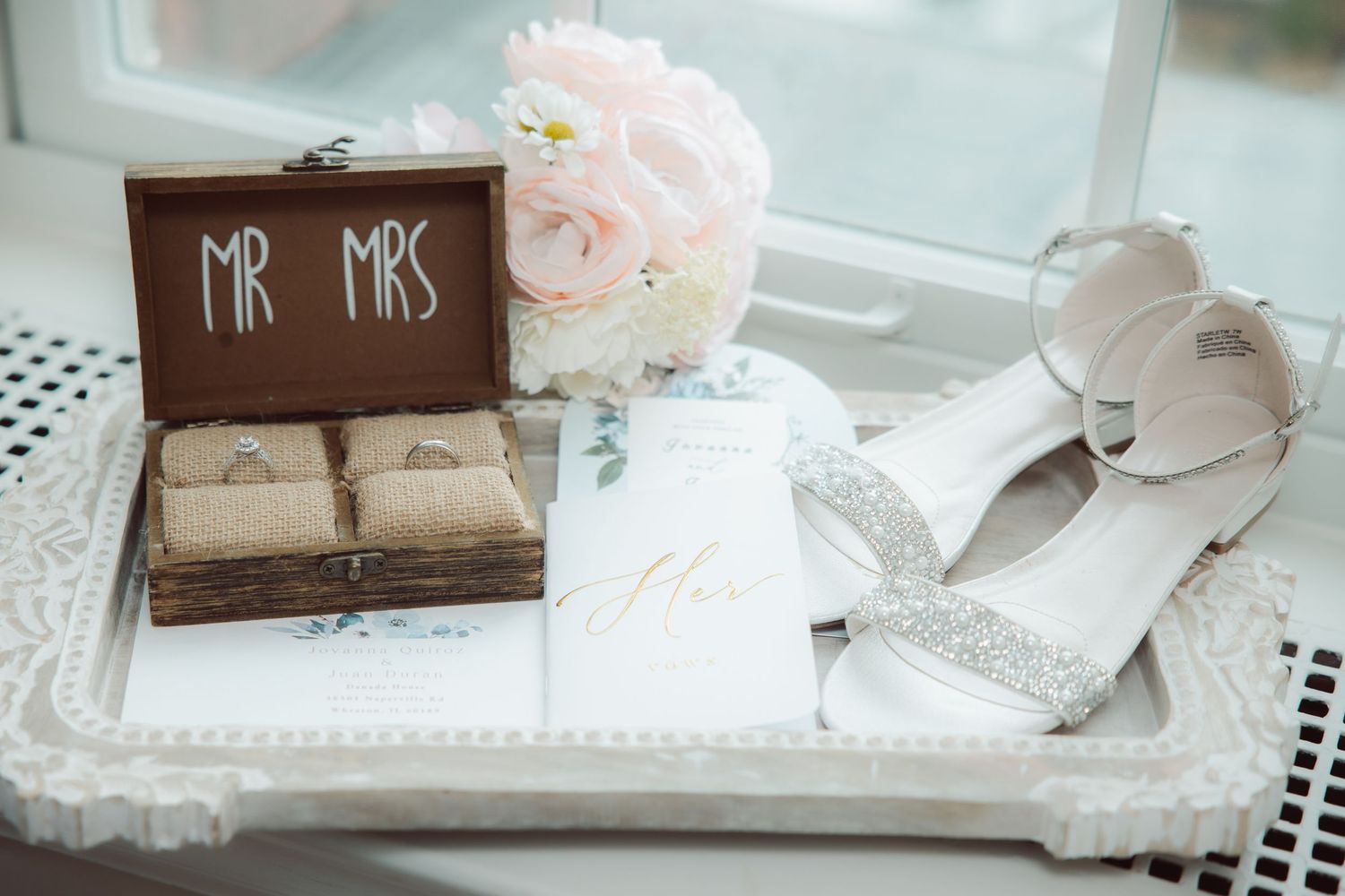 Wedding flat lay with Mr and Mrs ring box, bridal heels, bouquet, and vow booklet.