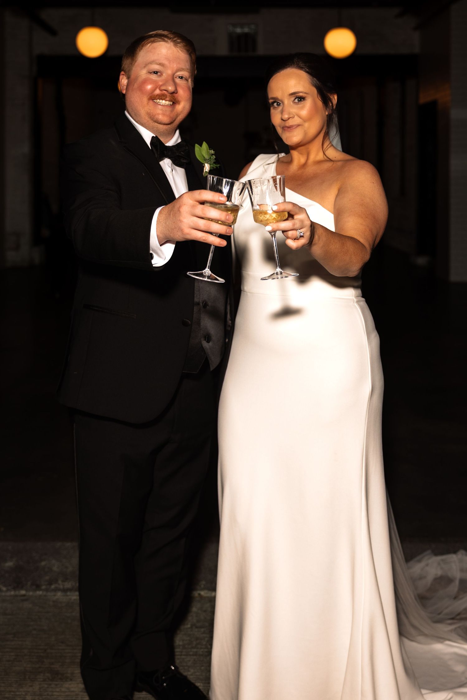 Happy bride and groom clinking champagne glasses together at their wedding reception.