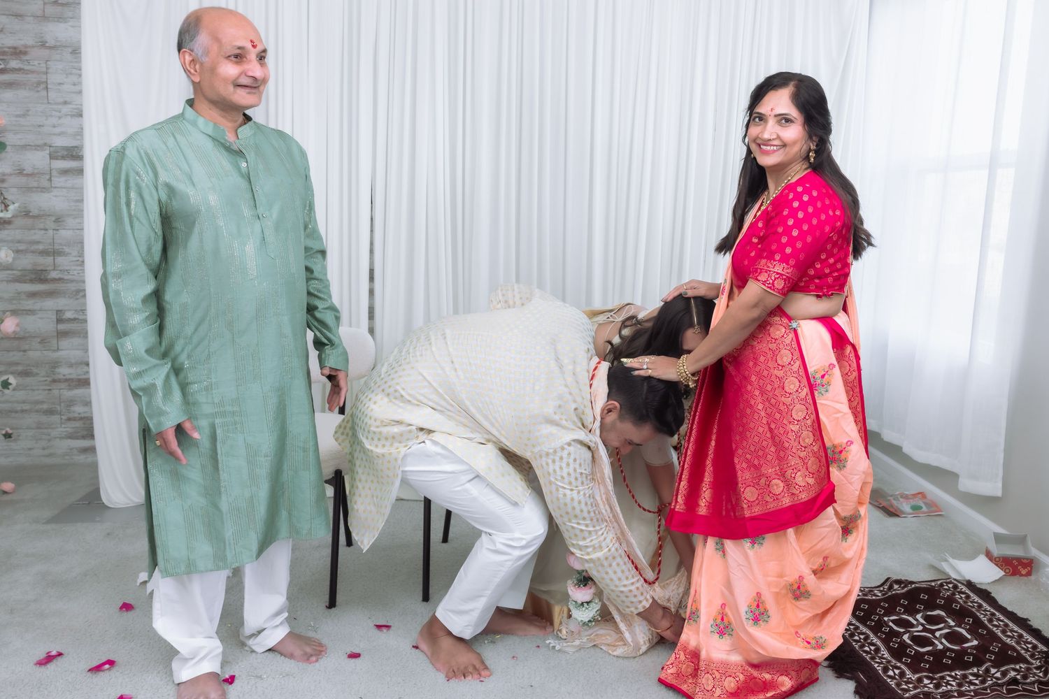 Indian wedding blessing ceremony with groom bowing to elders in traditional colorful attire.