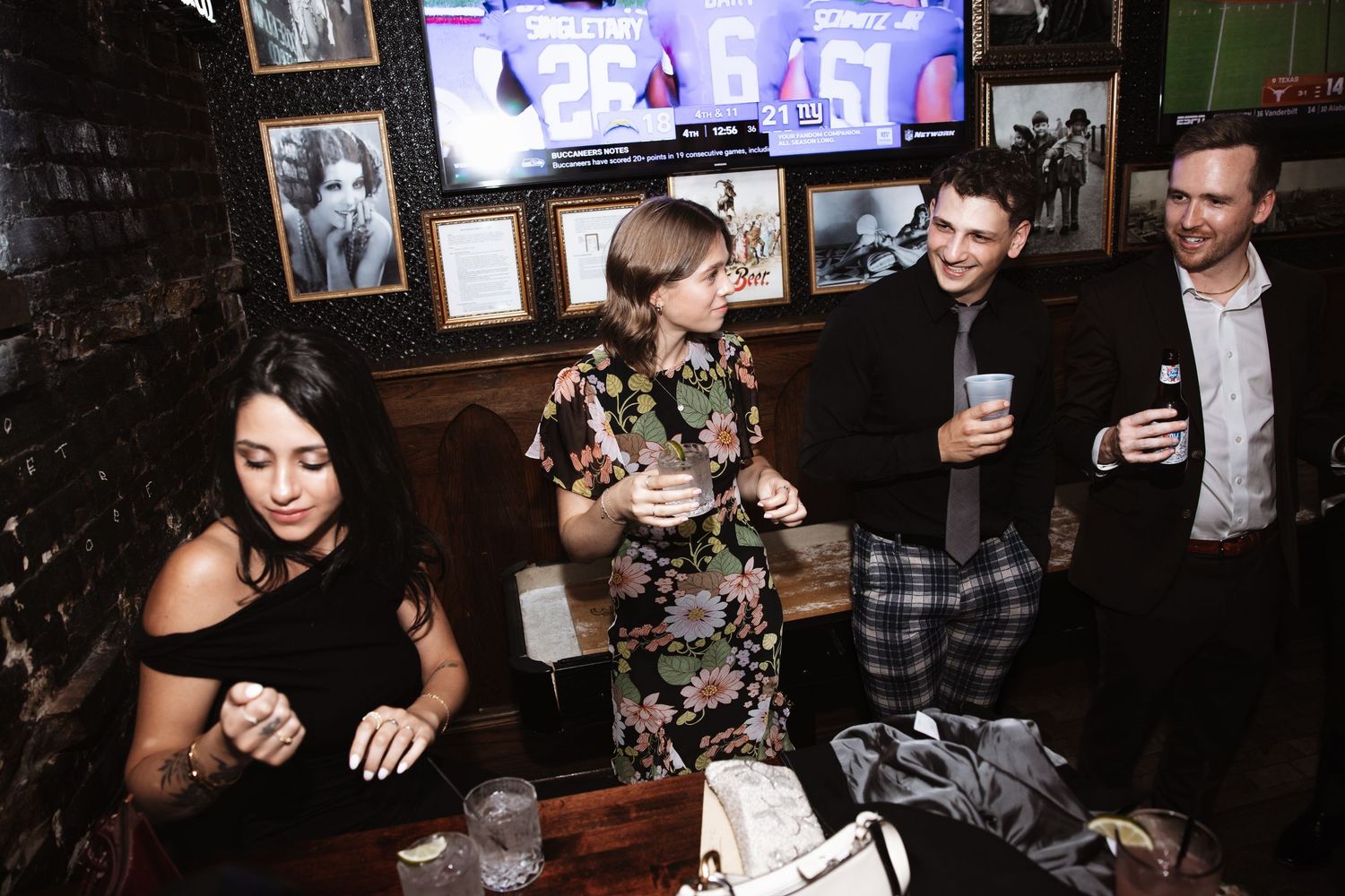 Group of elegantly dressed guests mingling and drinking at indoor wedding reception party.