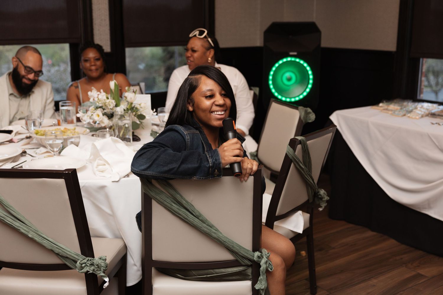Woman laughing while seated at an elegantly decorated banquet table during a celebration.
