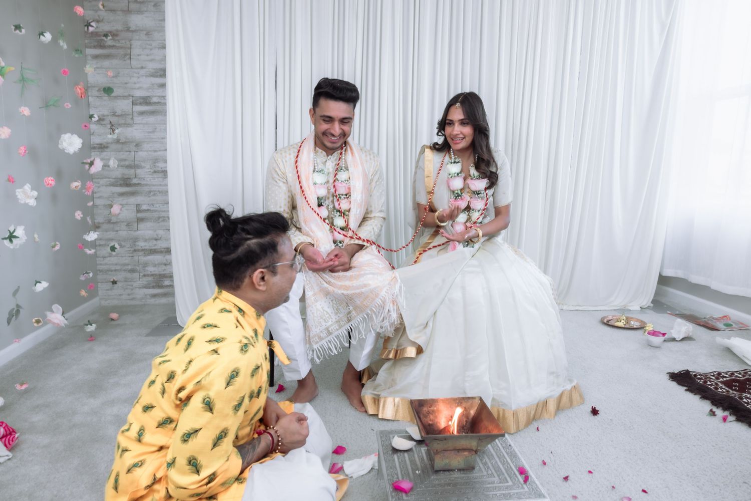 Bride and groom seated near sacred fire during traditional Hindu wedding ritual.