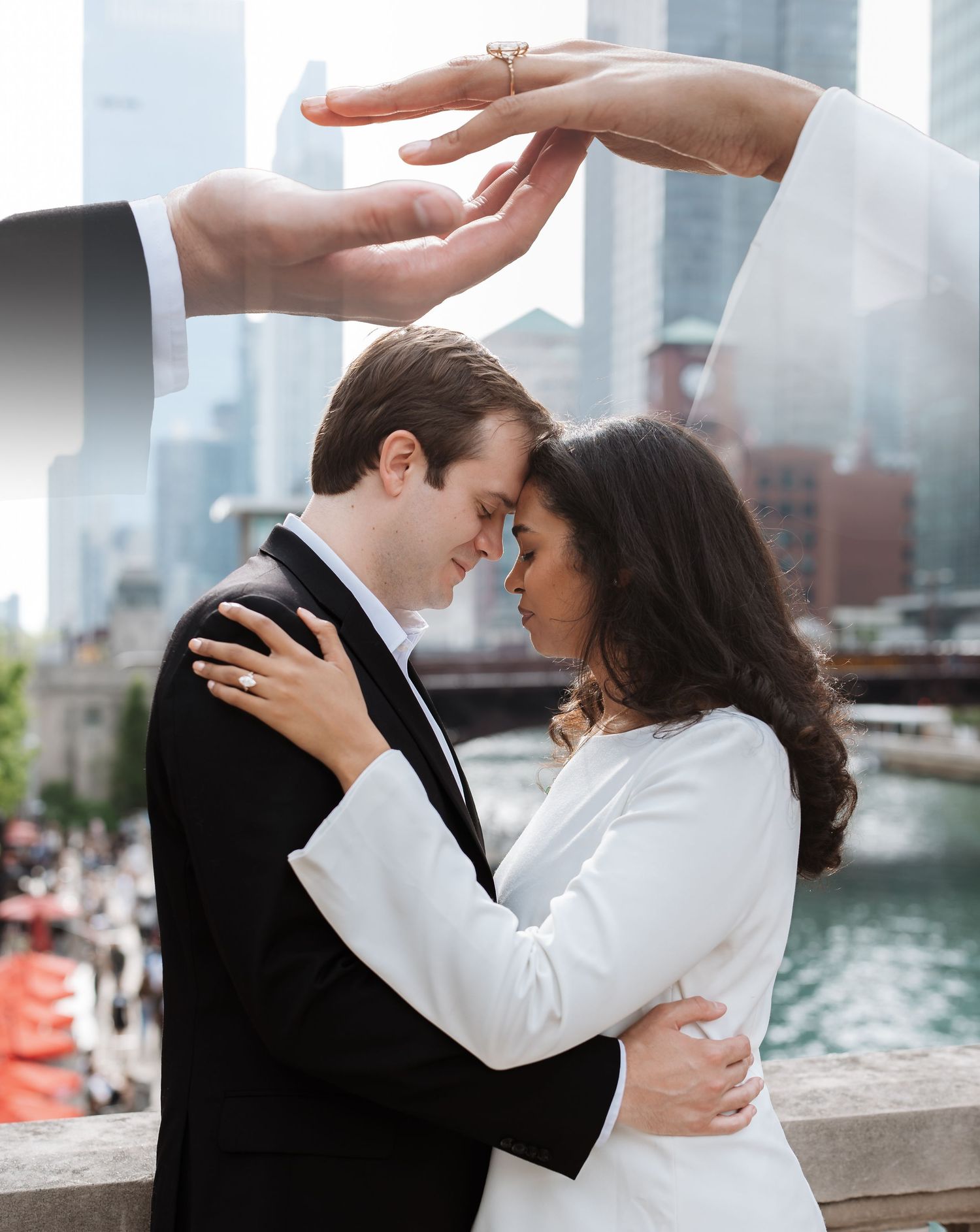Couple embracing tenderly with ring visible as hands frame them against Chicago skyline.