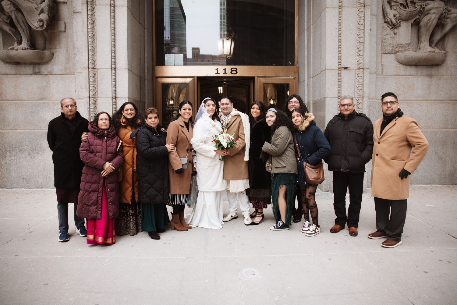 Wedding party group photo outside building 118 in Chicago during a winter elopement.